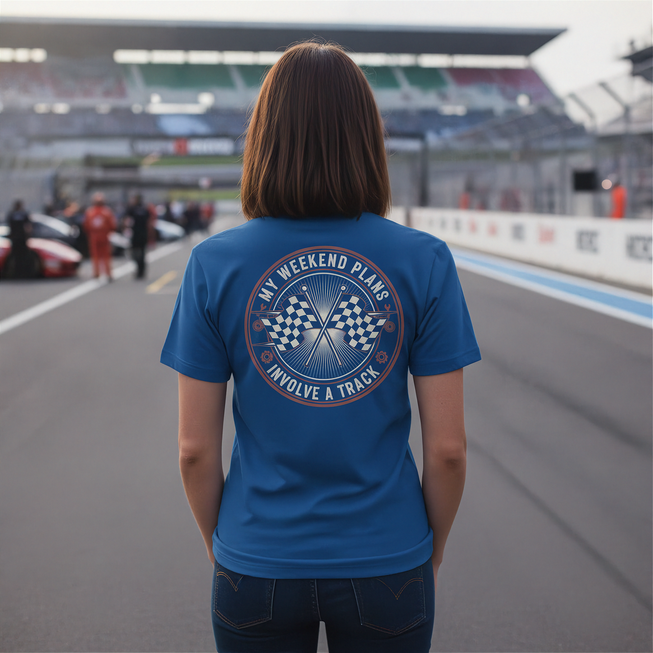 Woman wearing a blue t-shirt with a track-themed design on a race track.