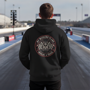 Man wearing a black hoodie with a track-themed design on a racetrack