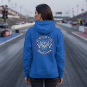 Man wearing a blue hoodie with a track-themed design on a race track background