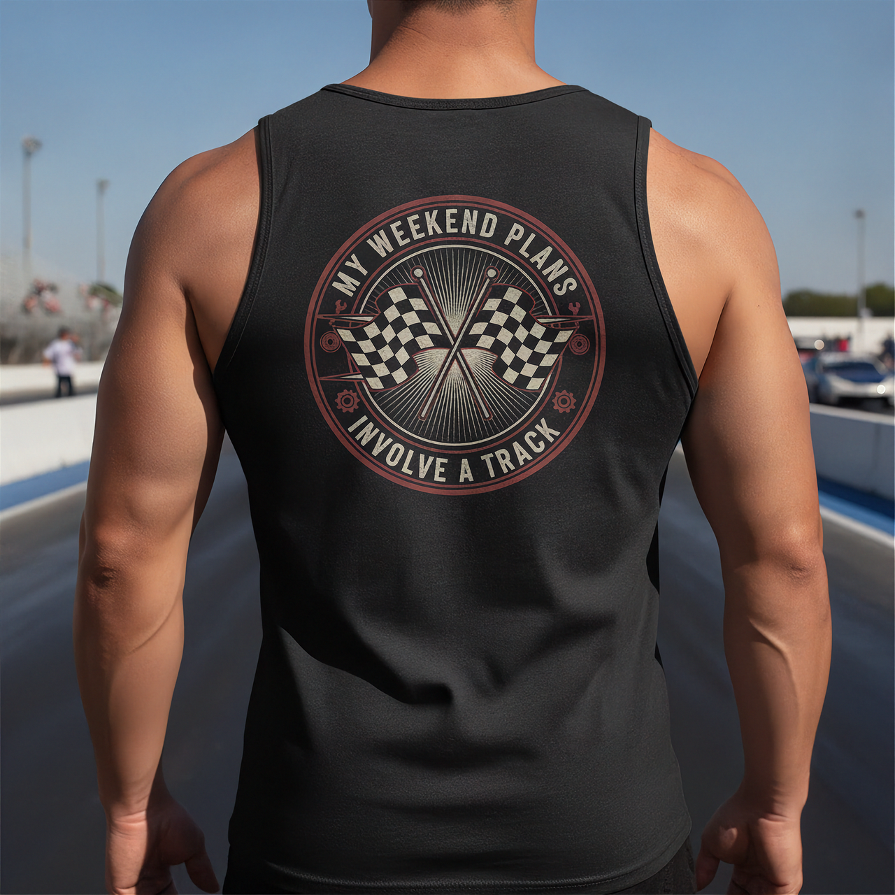 Person wearing a black tank top with a graphic design on the back, standing on a track.
