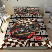 A bed dressed in a racing-themed bedding set featuring a black race car, brown-and-white checkered flags, and red 'Dirt Track Racing' text, shown in a bedroom setting.