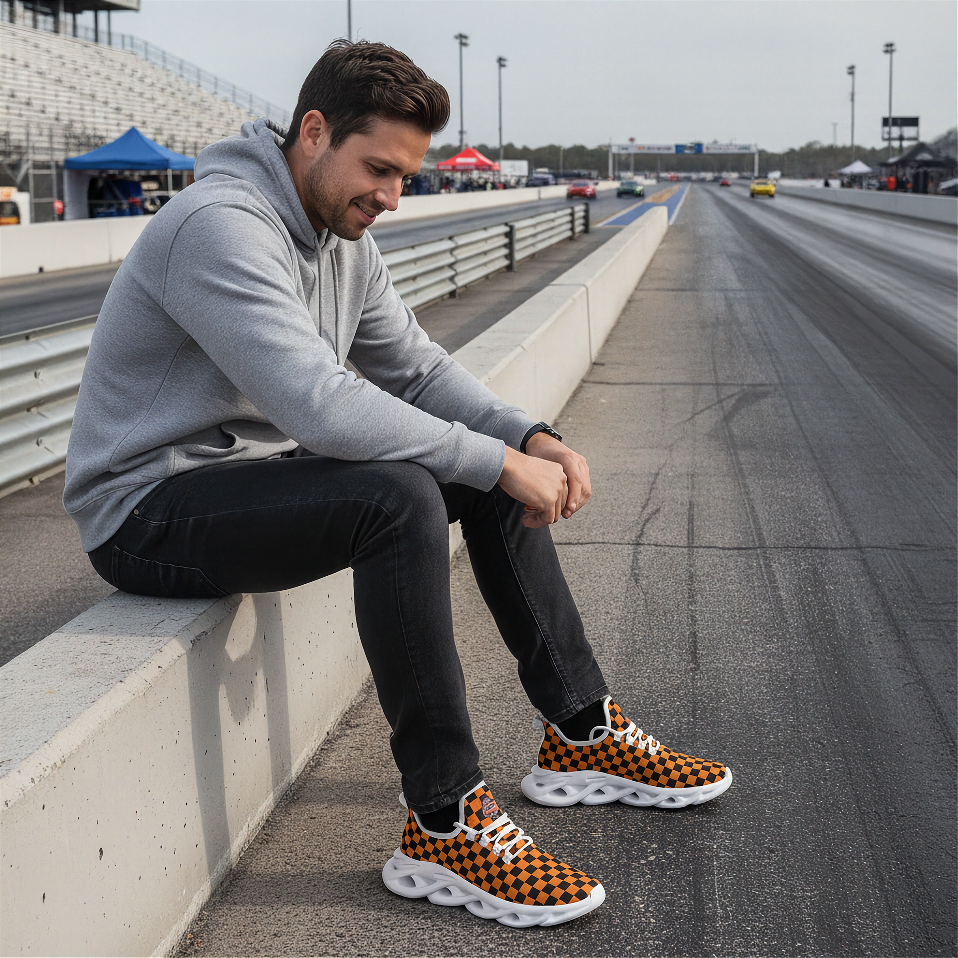 Man sitting on a race track wearing checkered sneakers