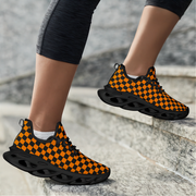 Orange and black checkered shoes worn by a person on stone steps.