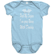A blue baby onesie with white text saying 'Pack My Diapers I am going Racing With Daddy' and a graphic pattern in the background.