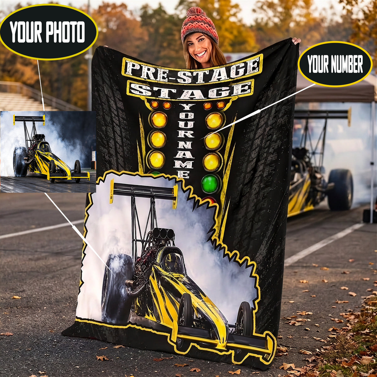 A woman stands on a racetrack holding a large custom dragster blanket. The print features a black background with a stylized dragster car, illuminated light bar, and the words 'PRE-STAGE' and 'CUSTOM NAME' .