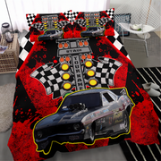 A racing-themed bedding set featuring a duvet cover and matching pillowcases with a black and red design, checkered flags, a turn signal graphic, and a large muscle car illustration, shown on a bed in a bedroom setting.