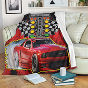 Custom-name red Mustang blanket draped over a cream sofa, showing drag racing starting lights and its white microfleece underside.⠋