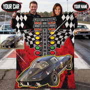 Couple holding a personalized drag racing blanket at the dragstrip, with callouts showing custom car photo and name placement.