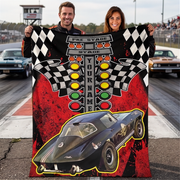 Couple displaying a red-and-black drag racing blanket with a black race car photo, starting-light tree and sample YOUR NAME text.