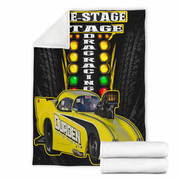 A white fleece throw blanket with a printed drag racing design, shown flat with a folded corner revealing the white sherpa lining. Two folded white towels are placed in front of the blanket on a plain white background.