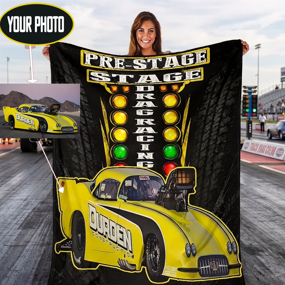 A woman holds up a large black and yellow drag racing themed blanket or poster at a racetrack. The design features the words 'PRE-STAGE DRAG RACING' with traffic light graphics, a yellow drag car with 'DURDEN' lettering, and a small inset photo of a yellow race car on a track.