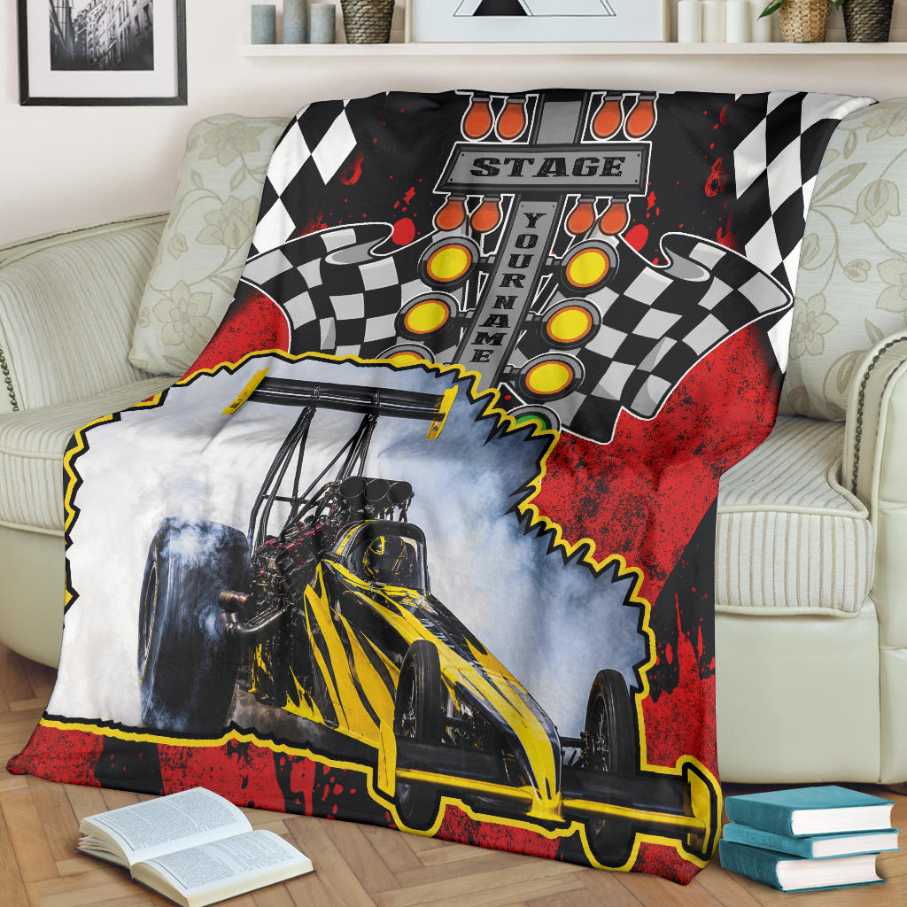 Personalized dragster blanket spread across a cream sofa, showing the yellow-and-black car photo and sample name.