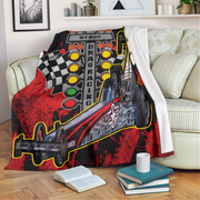 Personalized dragster blanket draped over a cream sofa, with white microfleece backing folded outward.