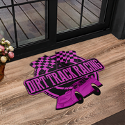 A rectangular doormat with a vibrant purple and black dirt track racing design, placed on a wooden deck in front of a glass door.