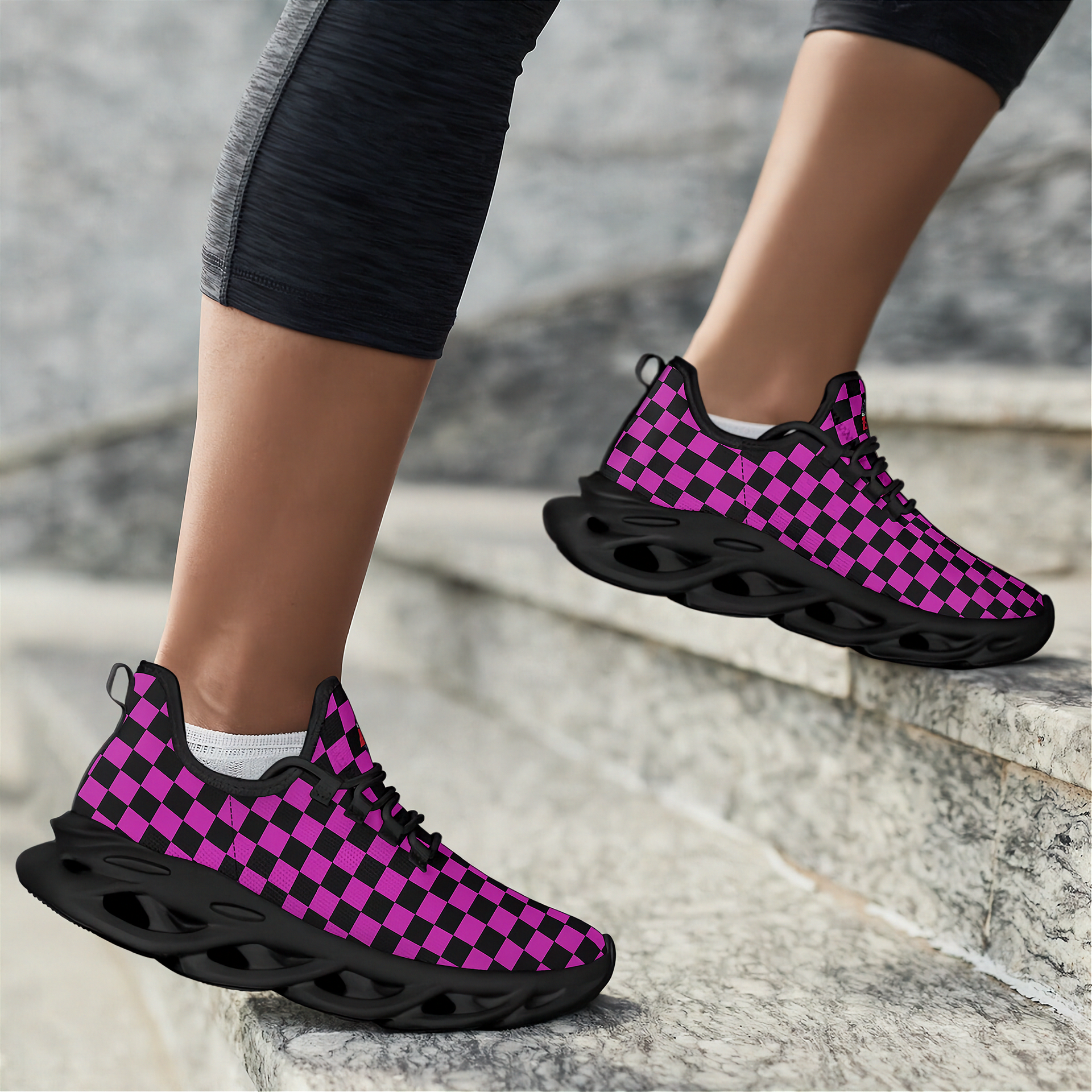 Black and pink checkered sneakers worn on a stone staircase.