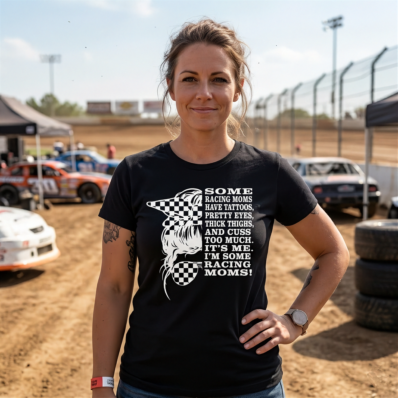 Premium black women's graphic t-shirt mockup featuring a checkerboard bandana messy bun graphic alongside bold white text that reads "SOME RACING MOMS HAVE TATTOOS, PRETTY EYES, THICK THIGHS, AND CUSS TOO MUCH. IT'S ME. I'M SOME RACING MOMS!".