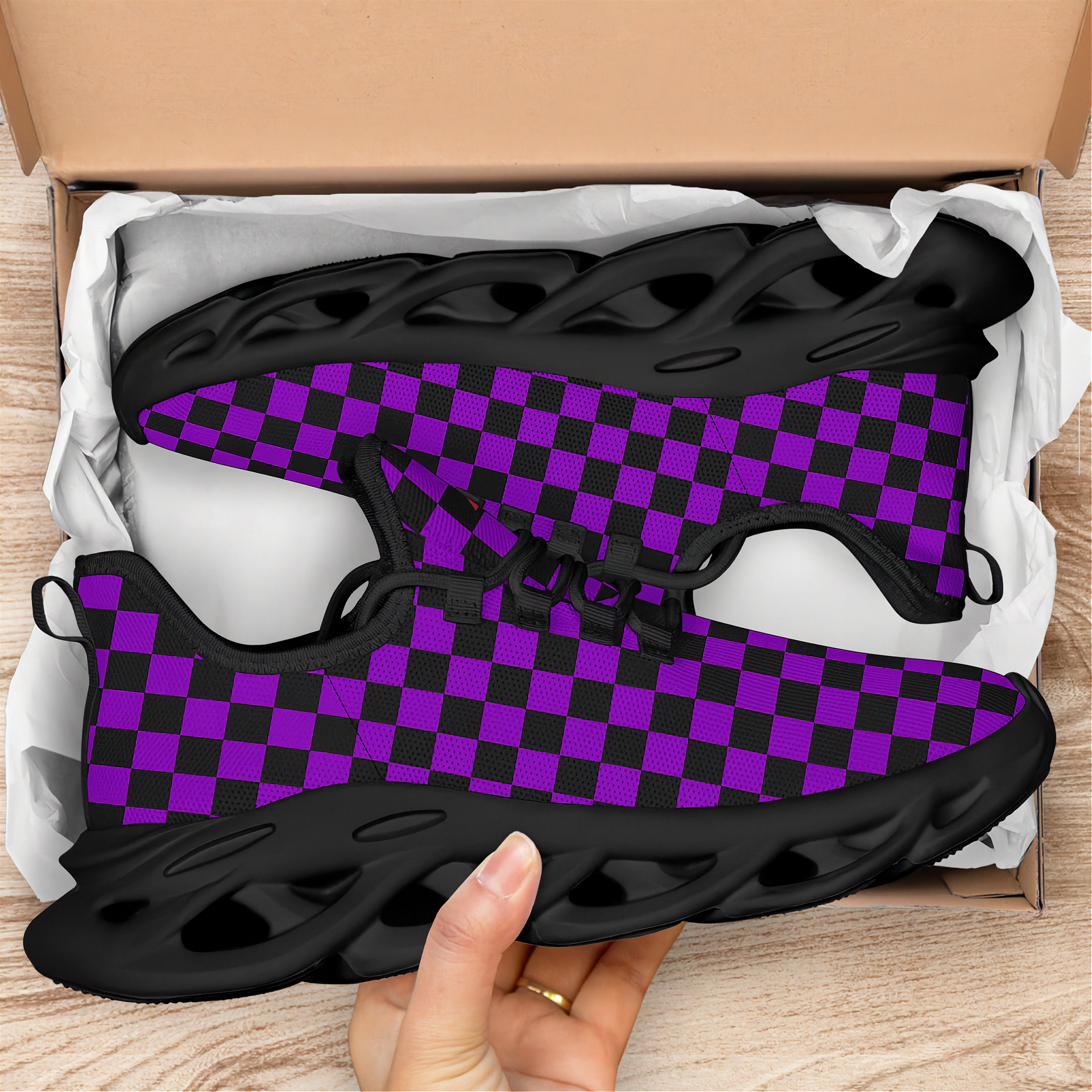 Black and purple checkered sneakers in an open box on a wooden surface
