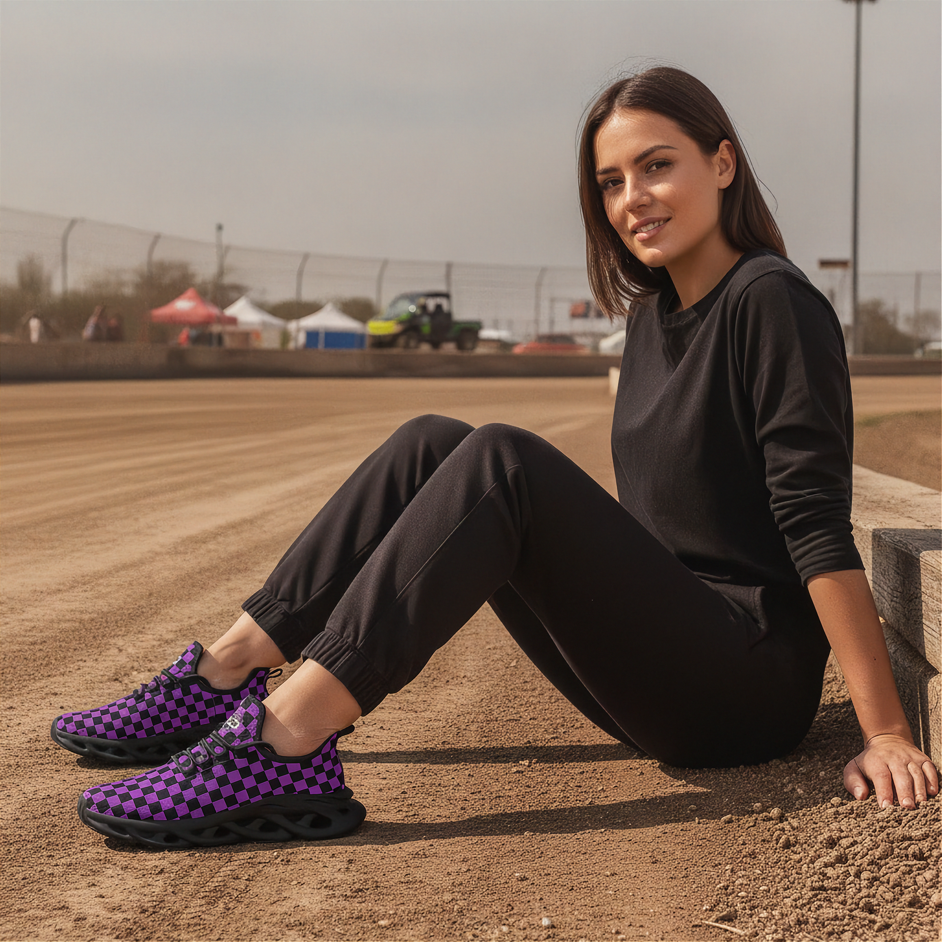 Woman sitting on a dirt track wearing black and purple checkered shoes
