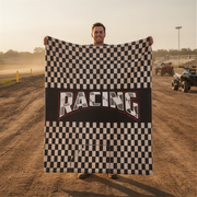 Man holding a checkered flag with 'Racing' text on a dirt track.