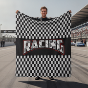 Person holding a checkered flag with 'Racing' text on a race track