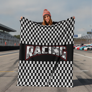 Woman holding a checkered racing flag with 'Racing' text on a race track.