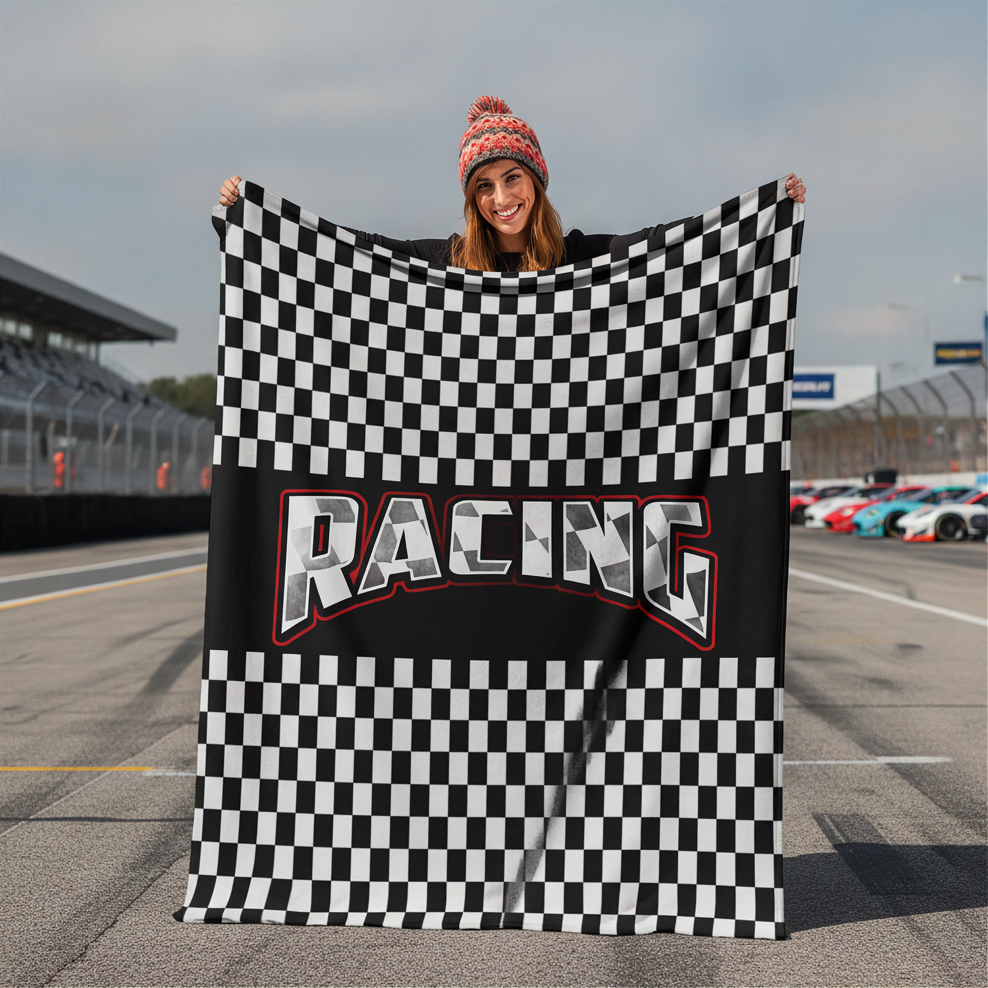Woman holding a checkered racing flag with 'Racing' text on a race track.