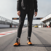 Woman in a race track wearing a checkered pattern orange boots