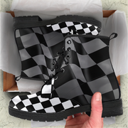 Black and white checkered boots in a box with a hand holding one boot.
