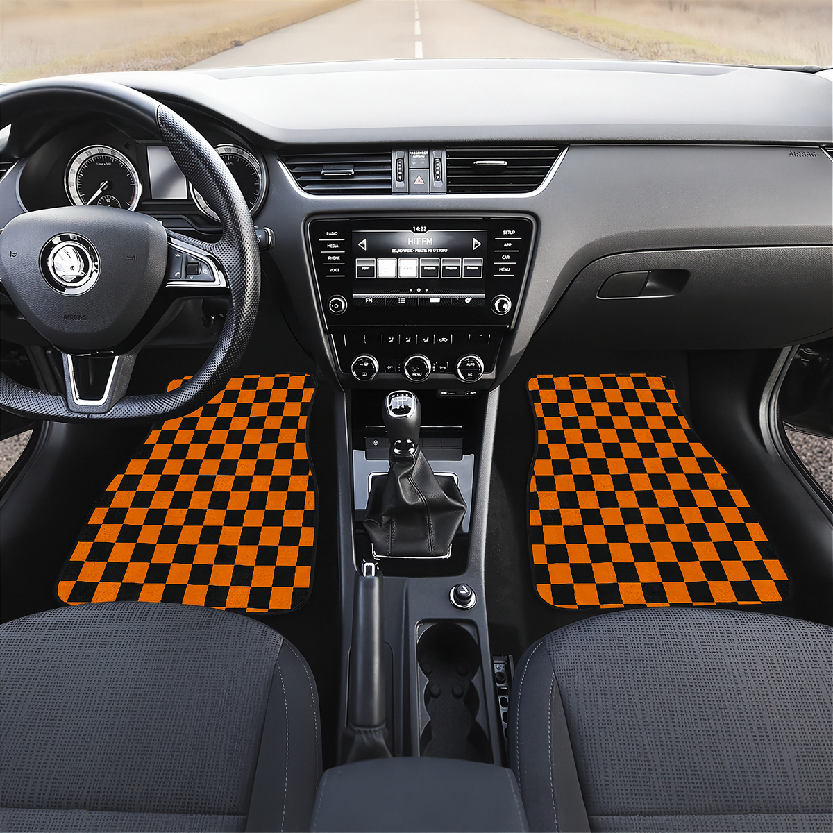 A pair of black and orange checkered car floor mats installed in the front of a car interior, shown from a top-down perspective with the dashboard, steering wheel, and center console visible.