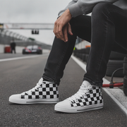 Man wearing checkered high-top sneakers on a racetrack