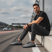 Man sitting on a race track wearing checkered shoes