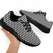 Black and white checkered sneakers held by a hand on a white background