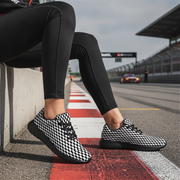 Person wearing checkered shoes on a race track