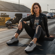 Woman sitting on a race track wearing checkered shoes