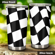 Two stainless steel tumblers with black and white checkered pattern on a wooden surface with a blurred green background.