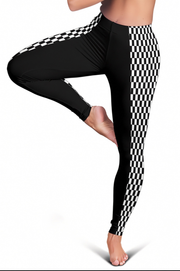 Black leggings with a black and white checkered pattern down the sides, shown on a model in a yoga tree pose against a white background.