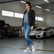 Woman standing in a garage with a sports car in the background