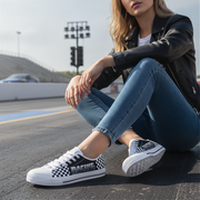 Person wearing checkered sneakers sitting on a road with a blurred background