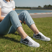 Woman wearing checkered shoes sitting on grass with a blurred background