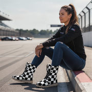Woman sitting on a race track wearing checkered boots