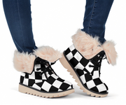 Black and white checkered boots with fluffy fur trim worn by a person in blue jeans.