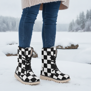 Black and white checkered boots worn with blue jeans in a snowy landscape.