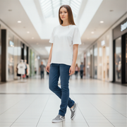 Woman in a white t-shirt and blue jeans standing in a shopping mall wearing checkered shoes