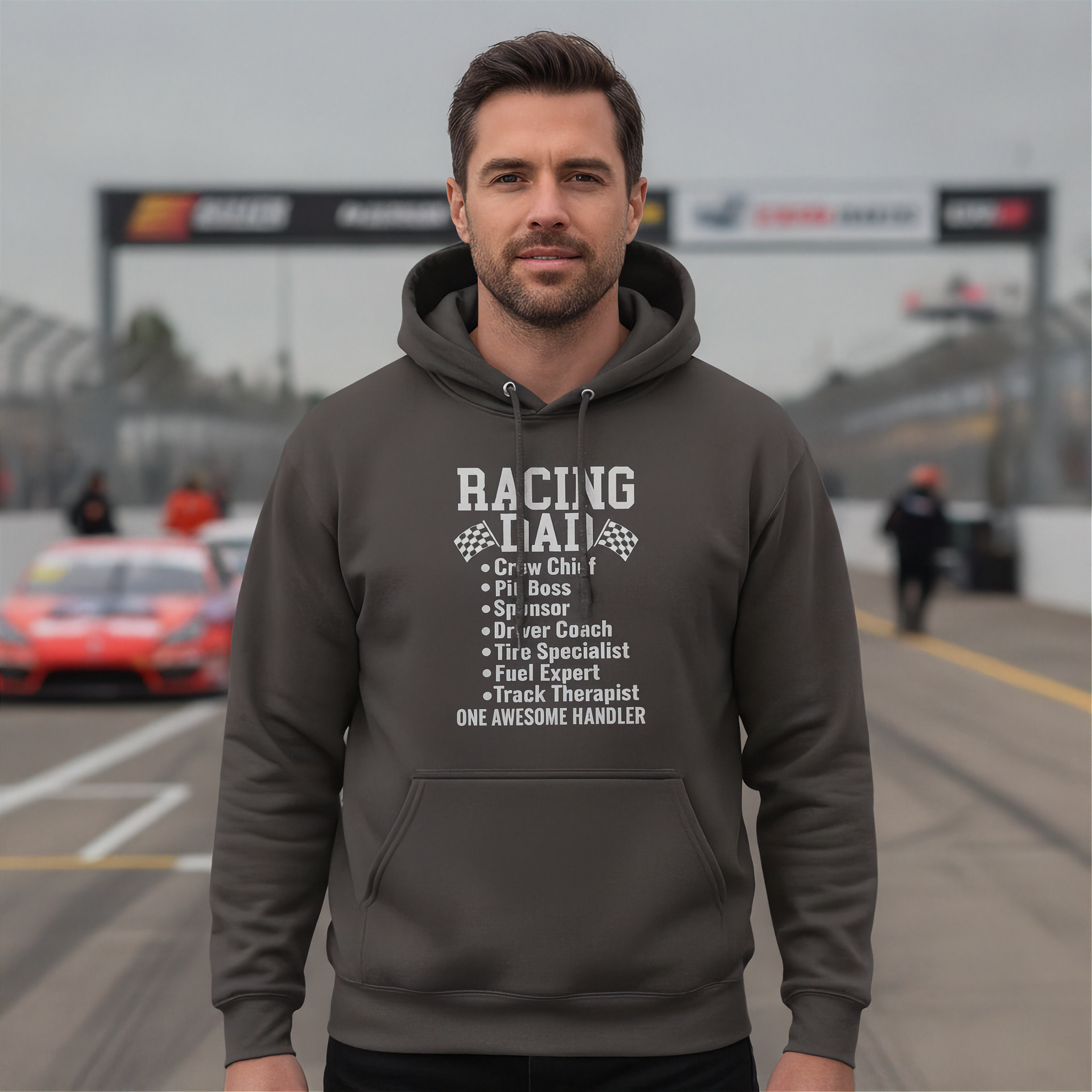 Man wearing a gray hoodie with racing-themed text on a race track background