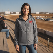 Woman wearing a gray jacket with a red racing daughter heart design at a race track