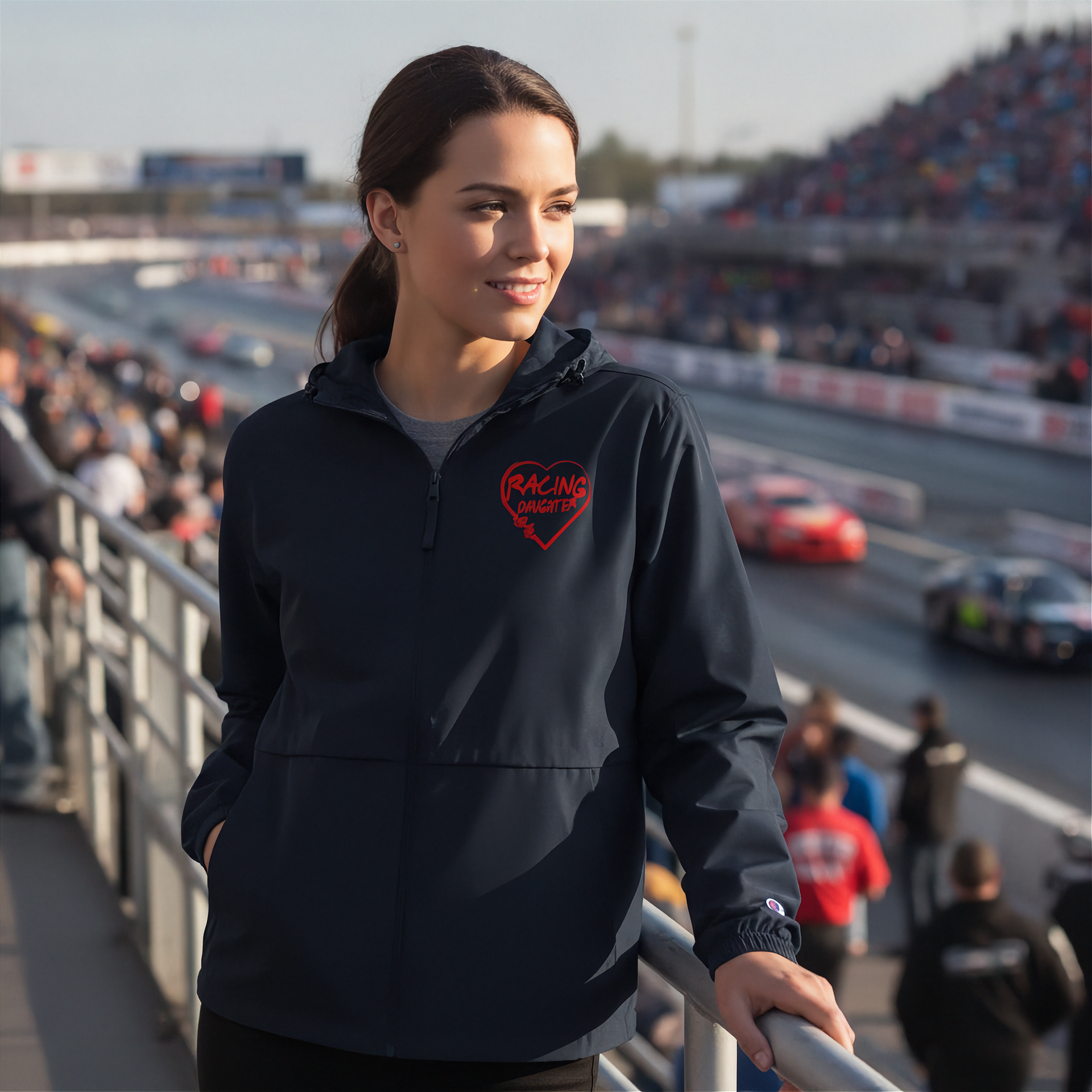 Woman wearing a black hoodie with a red racing daughter heart design at a race track event