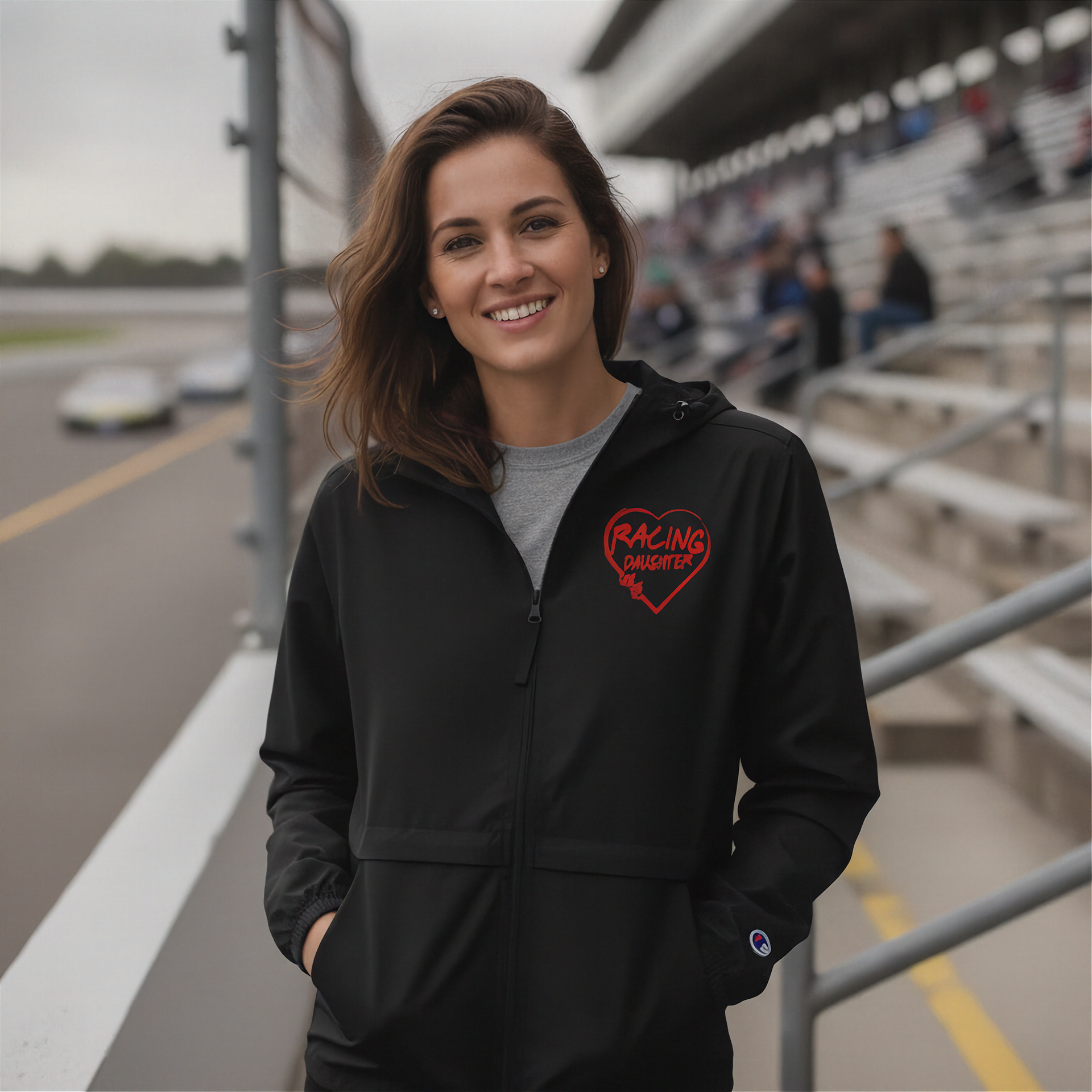 Woman wearing a black hoodie with a red heart design on a race track background