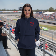 Woman wearing a navy blue jacket with a red heart logo at a race track.