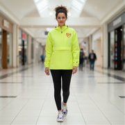 Woman wearing a bright yellow hoodie with a red racing daughter heart design in a mall setting