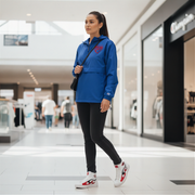 Woman wearing a blue jacket with a red racing daughter heart design in a shopping mall